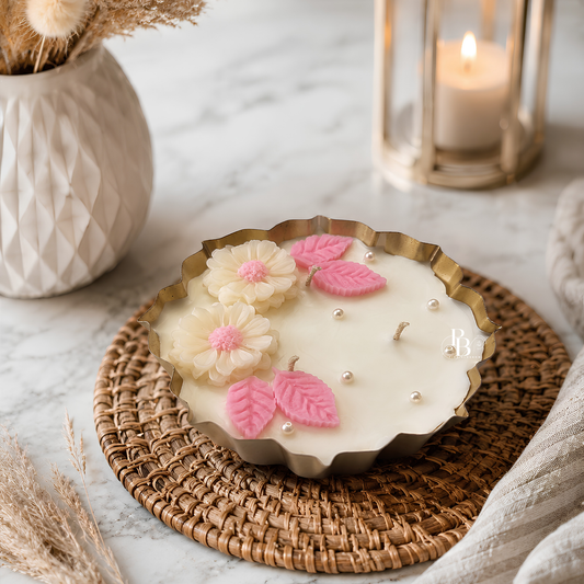 Festive candle in scalloped holder with white wax, pink blossoms, pearls and leaf decorations
