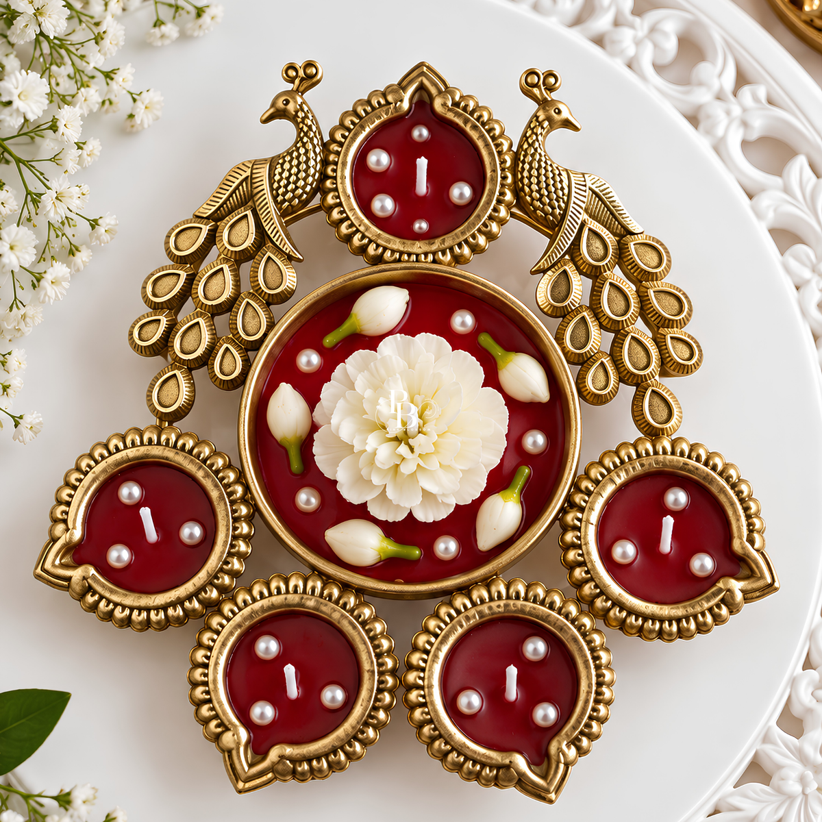 Decorative peacock-style candle with gold accents, red medallions, and white floral design