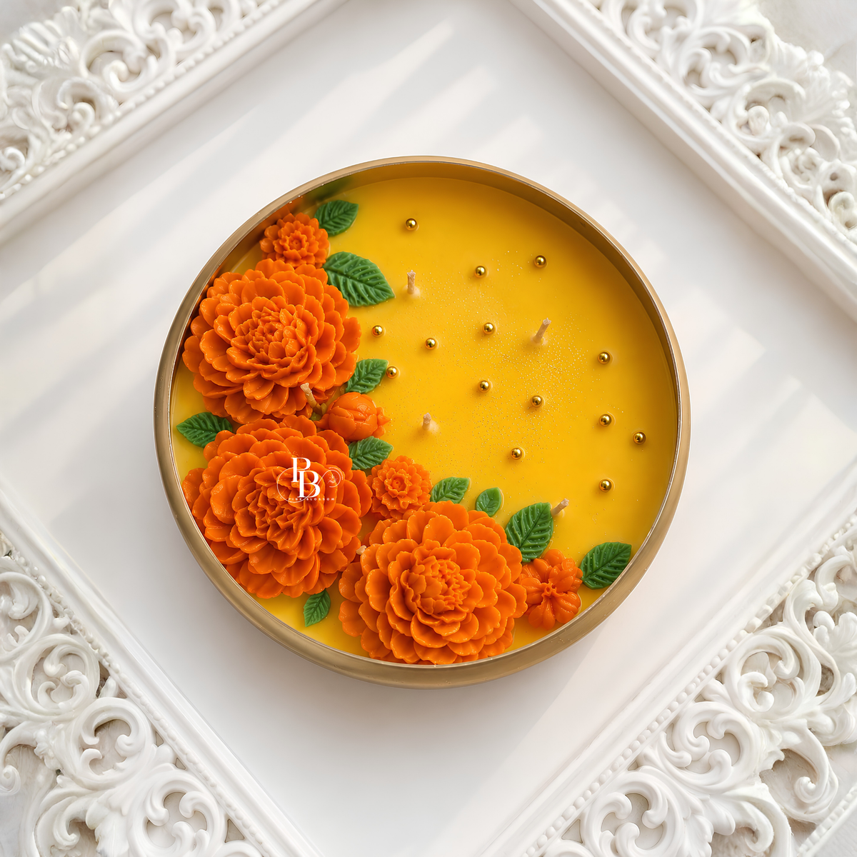 Round Marigold Maharani Urli™ candle with golden rim, orange flowers on yellow wax.