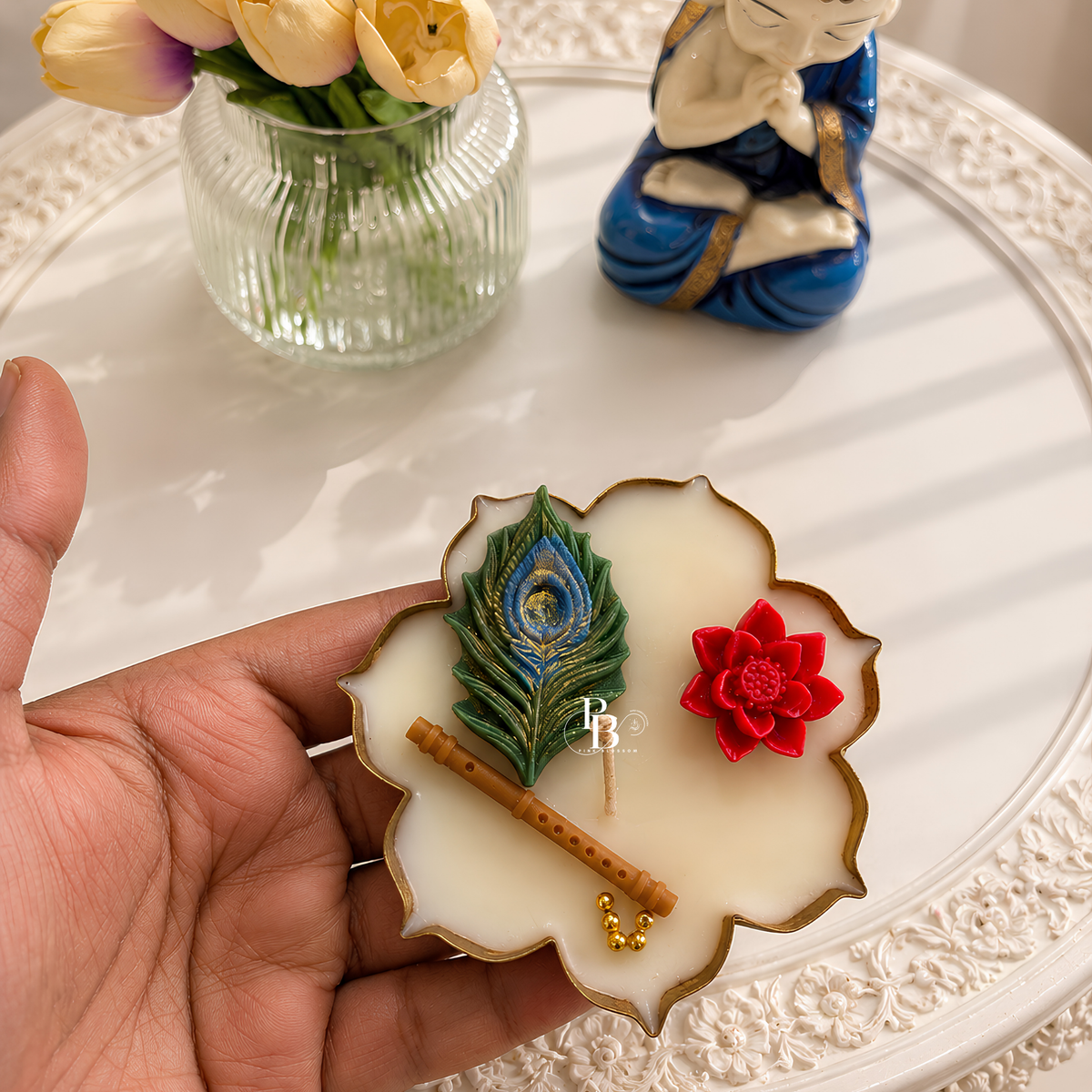 Decorative candle wax plate with peacock feather, red flower, bamboo sticks; hand-held