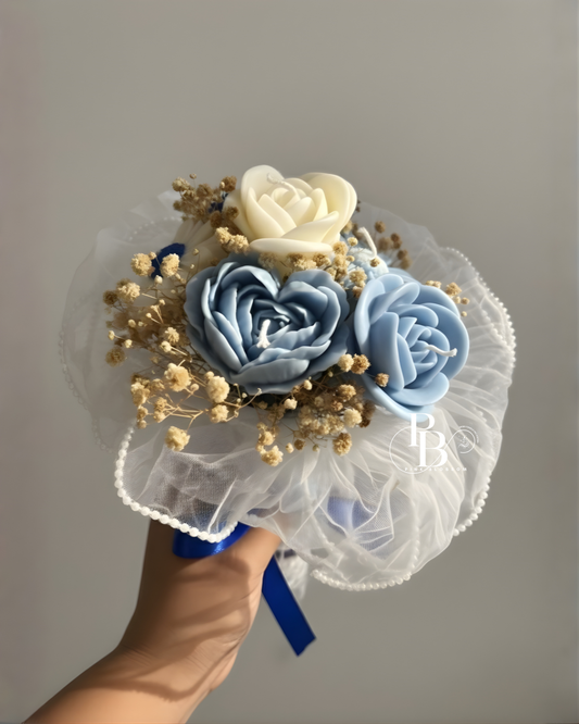 Floral bouquet candle with blue roses and cream flower, gold sprigs, tulle wrap, blue ribbon