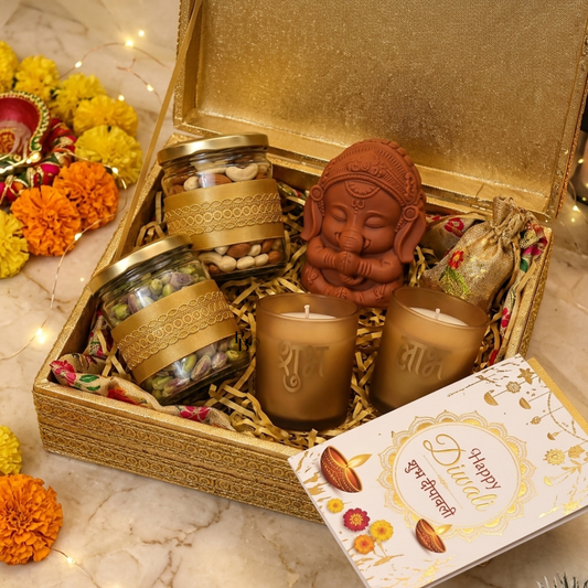 Open golden Diwali gift hamper with candles, jar favors, and Ganesha figurine