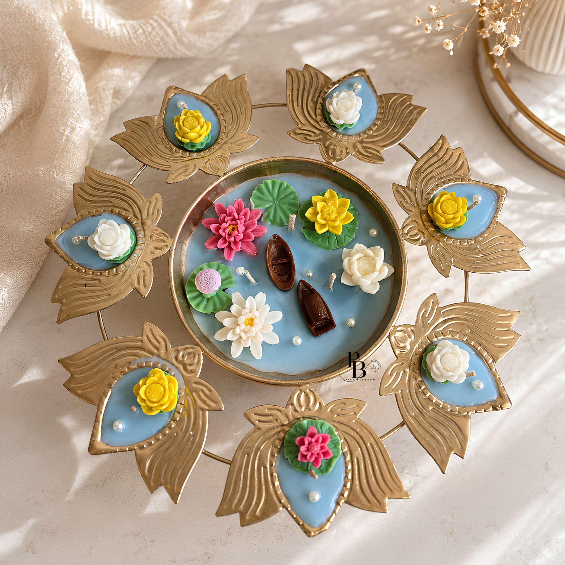 Blue tray floating urli candle with gold leaf holders and multicolor flower candle accents