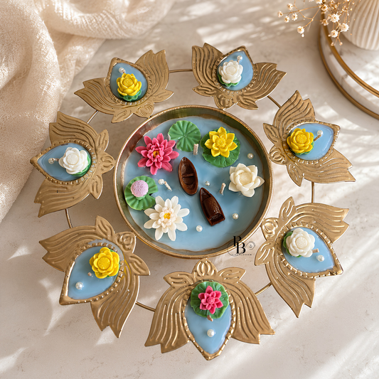 Blue floating urli candle tray with gold lotus leaf stems and colorful flower decorations