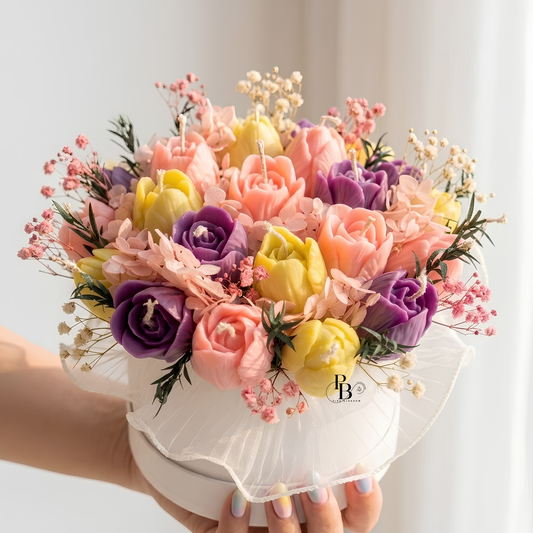 Pastel candle bouquet in white round tray, pink and purple roses with yellow blooms and sprigs