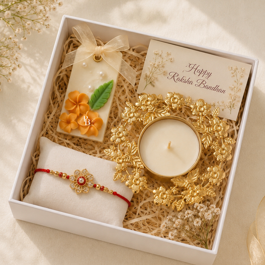 Raksha Bandhan gift hamper box with floral candle, gold holder, rakhi bracelet and card