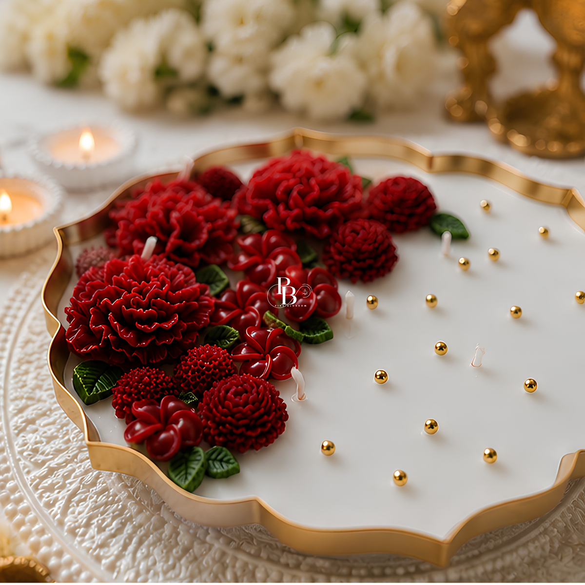 Red floral candle in gold-trimmed tray with red blooms over white wax