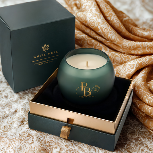 Dark green scented candle in gift box with rounded glass jar, wick, and gold logo