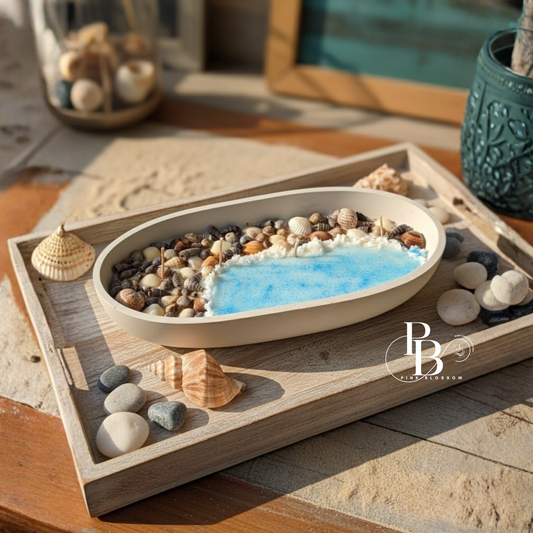 Seashell-shaped candle with blue wax and seashells, set in a wooden display tray