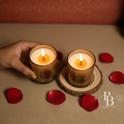 Lit engraved glass candles in gold-toned cups, one held by hand, deity design