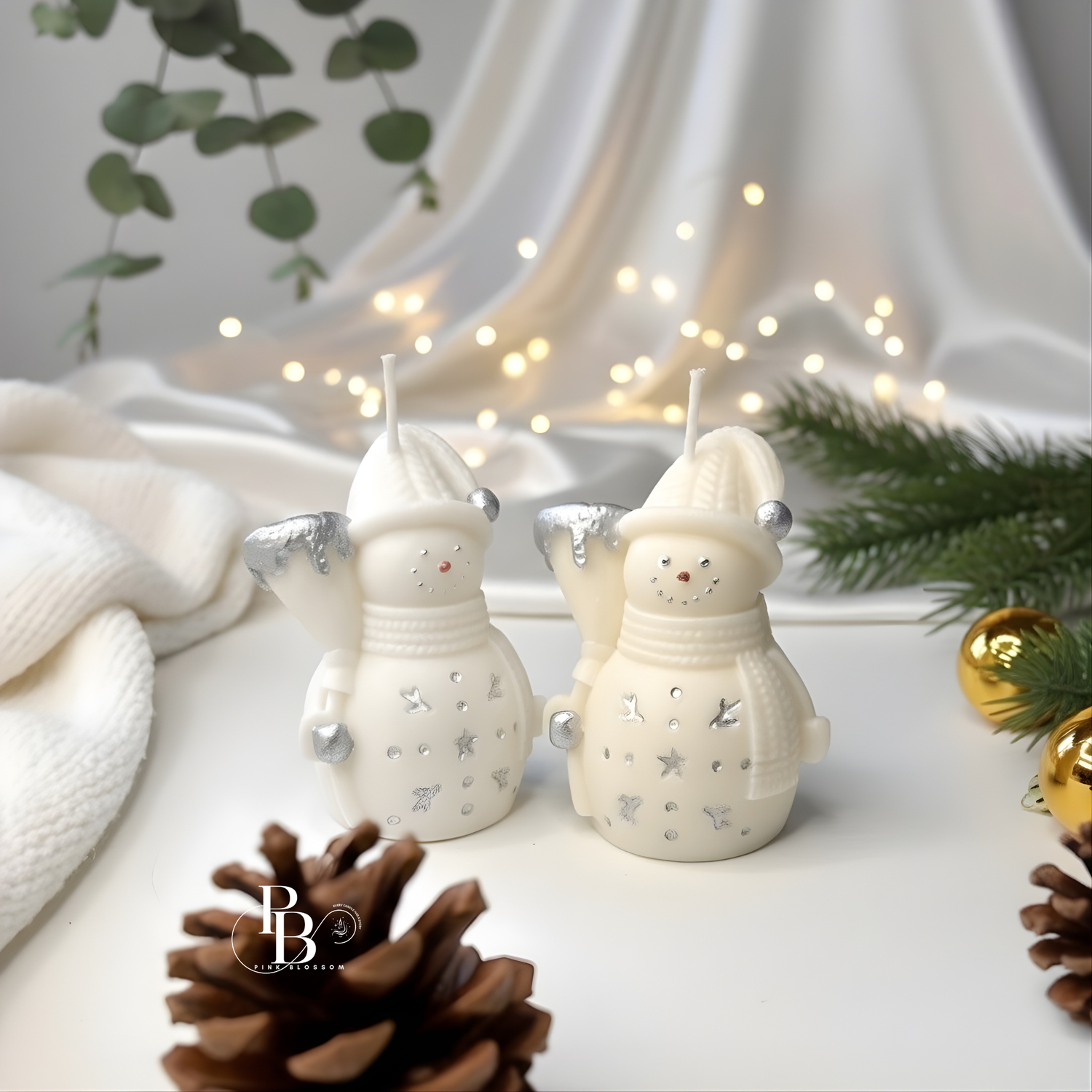 White snowman candle pair with silver arms, knit hats and button faces, unlit wicks