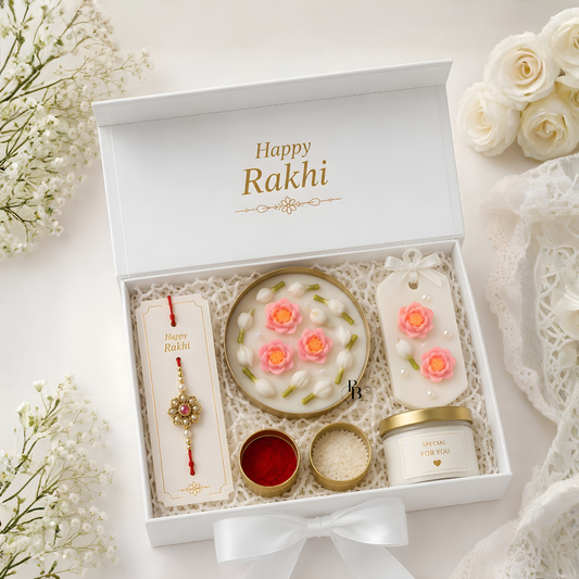 Rakhi gift hamper with round floral candle, rakhi bracelet, and aroma sachet.