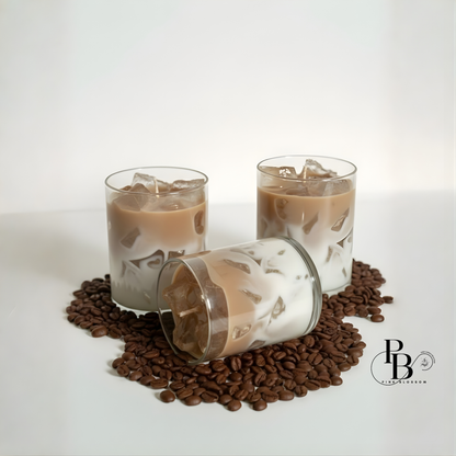Coffee-scent candles in clear glass with tan wax and floating wax pieces, one lying down