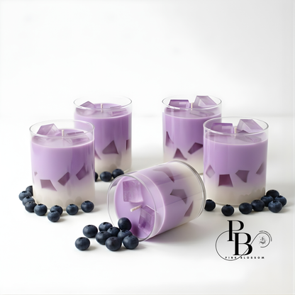 Purple candle set in clear glass with lavender wax and blueberry accents