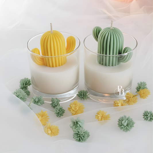 Two cactus candles in clear glass: yellow and green with wicks