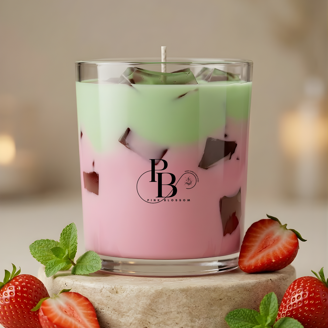 Berry-scent candle in clear glass with pastel pink and green wax layers