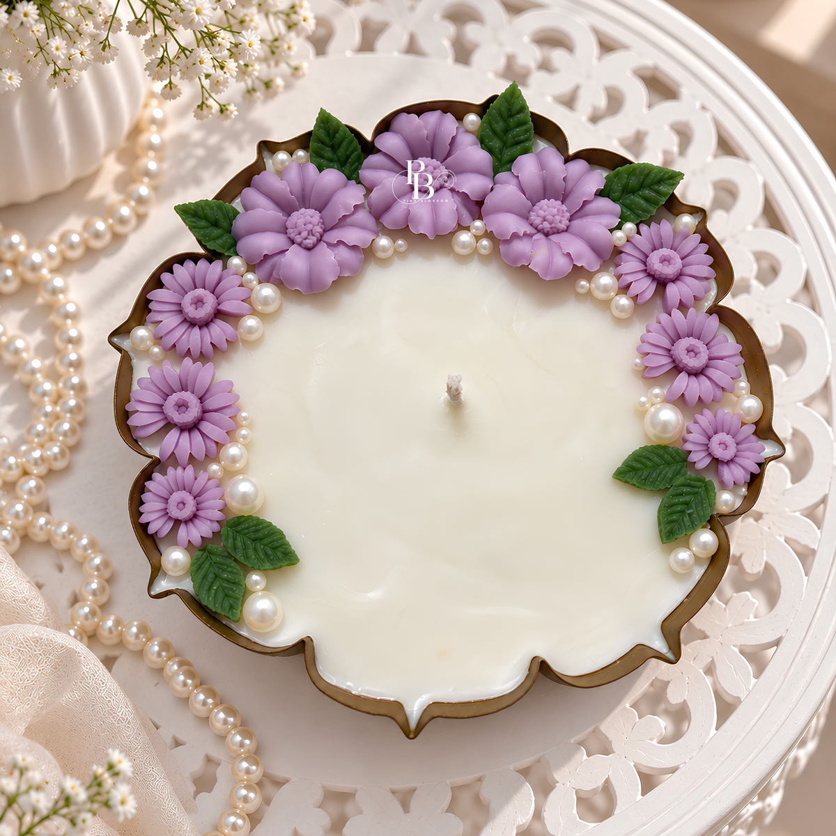 Decorative lilac pearl candle with lavender flowers, pearls, and a brown wax rim.