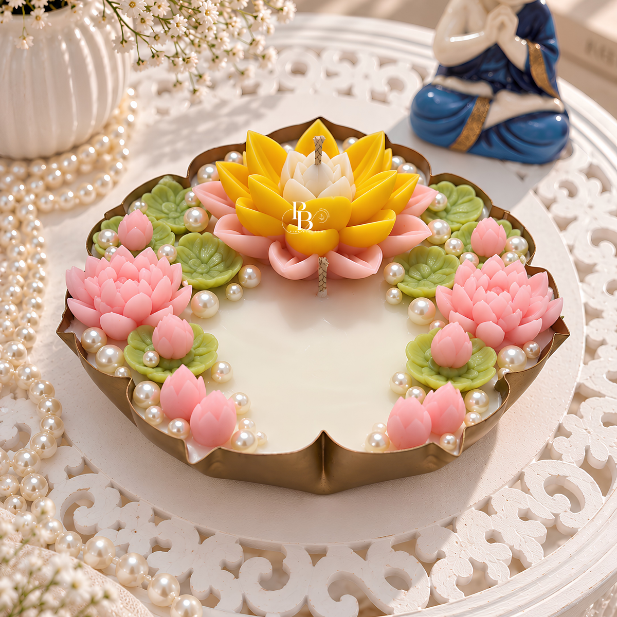 Floral pearl candle top with yellow and pink lotus flowers, green leaves, and wick