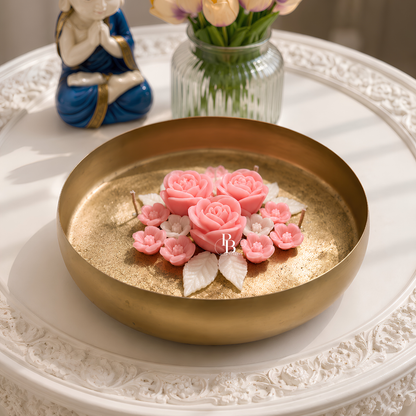 Gold-toned candle dish with pink rose and blossoms topper, shown on a tray