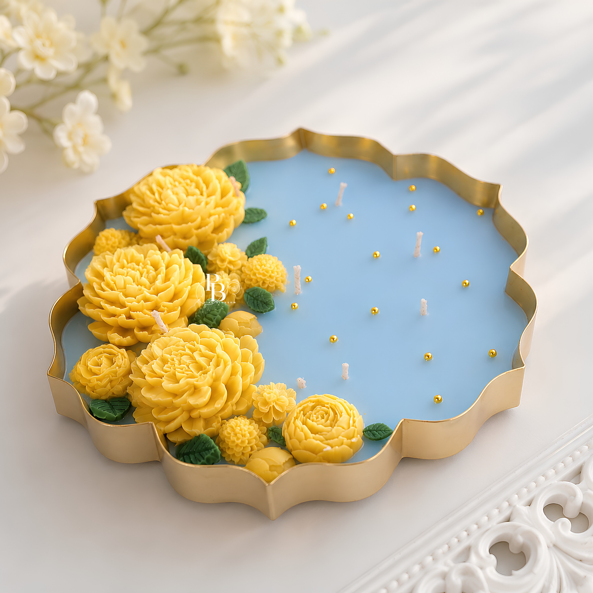Decorative urli candle with gold rim, blue wax, yellow flowers and teal leaves with small wicks